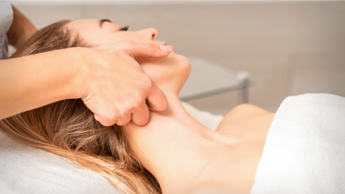 A woman lying in bed having a massage.