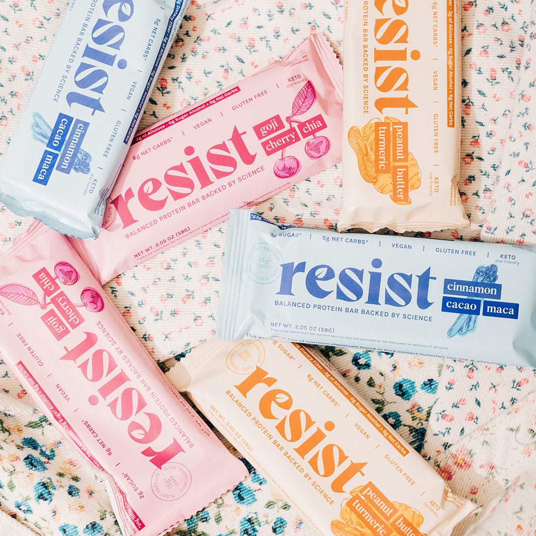 Resist protein bars in colorful packaging displayed on a patterned surface.